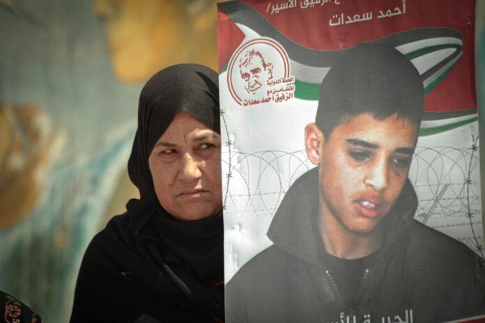 Palestinians take part in a protest in solidarity with prisoners in Israeli jails, in front of the Erez Crossing in Beit Hanoun in the northern Gaza Strip (Reuters)